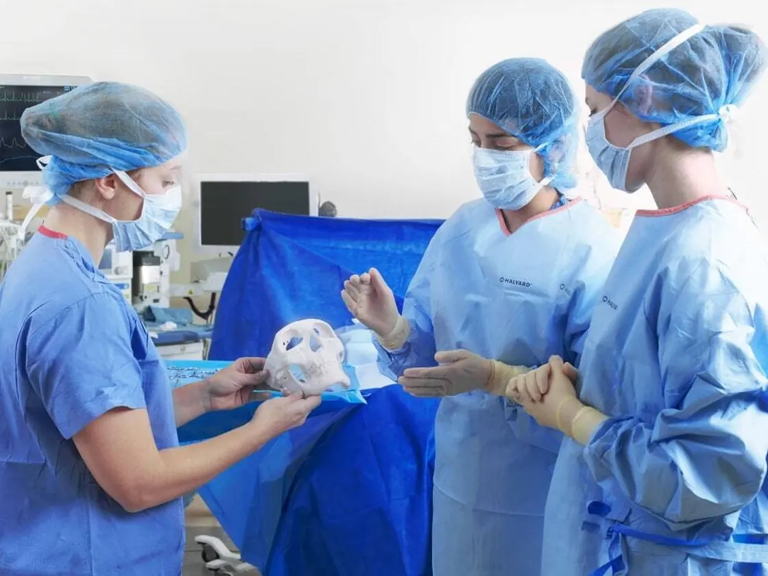 Surgical team reviewing a 3D printed anatomical skull model before an operation