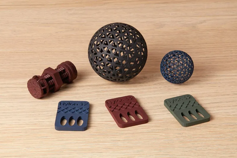 Dyed SLS PA12 parts in black, navy, oxblood and forest, including hollow lattice spheres