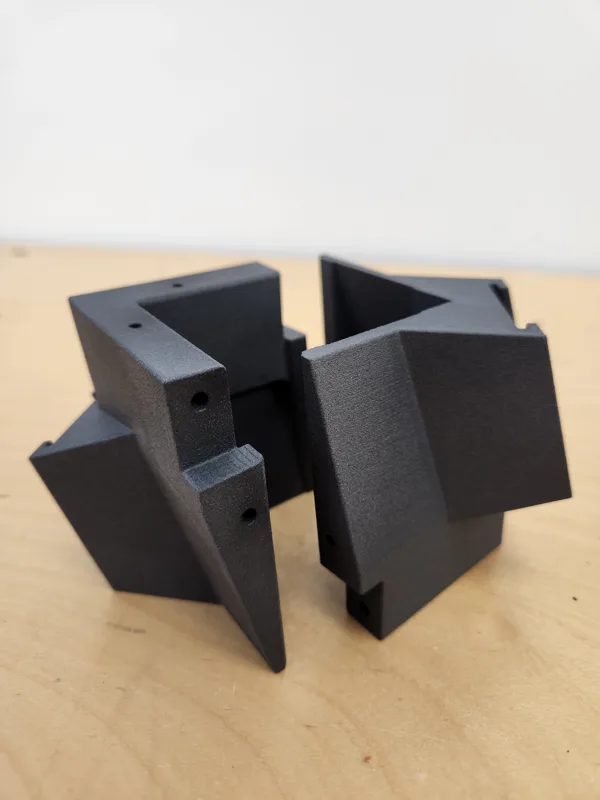 Black SLS nylon brackets mounted on plywood